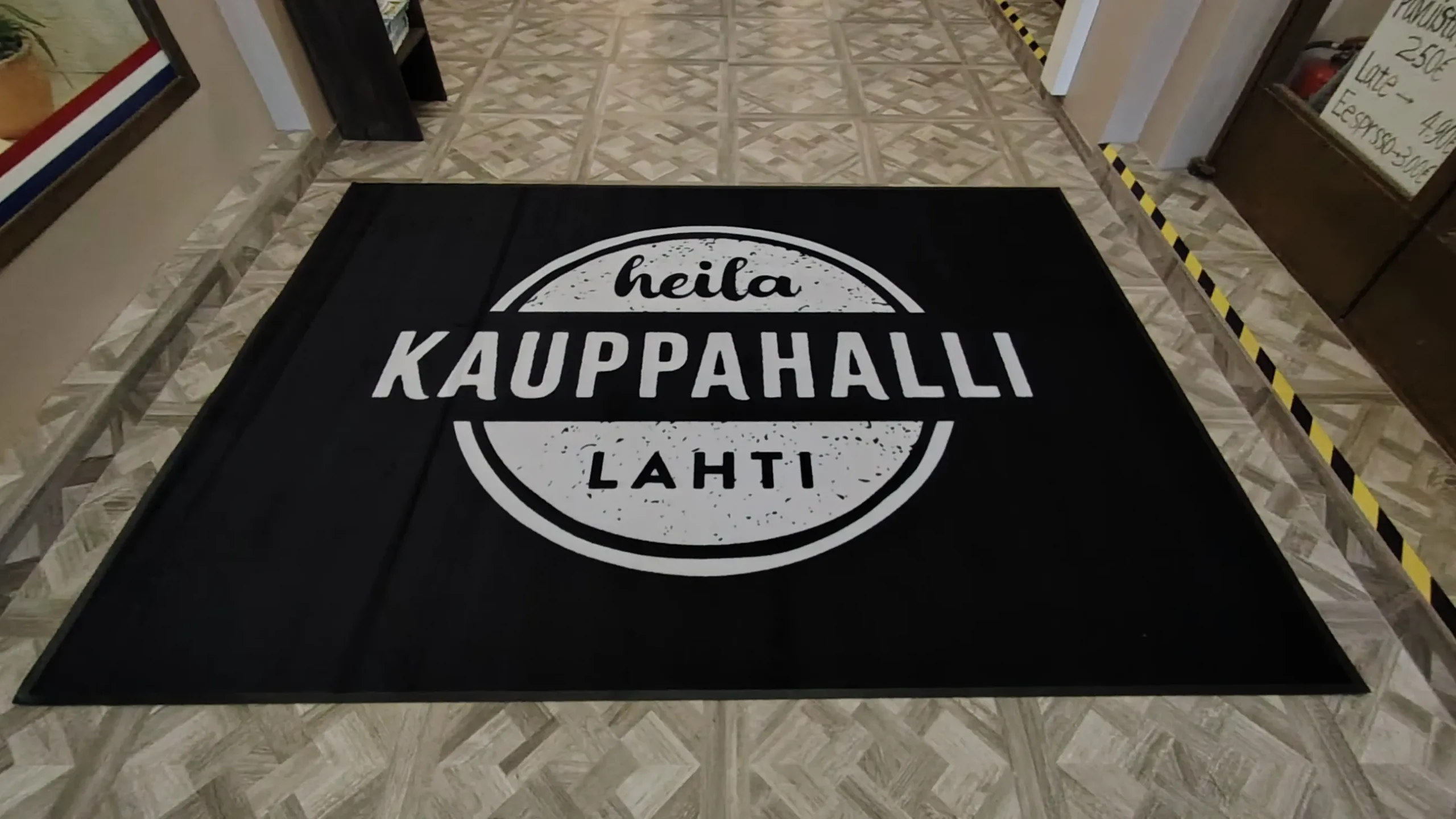 Logomatto sisäänkäynnillä